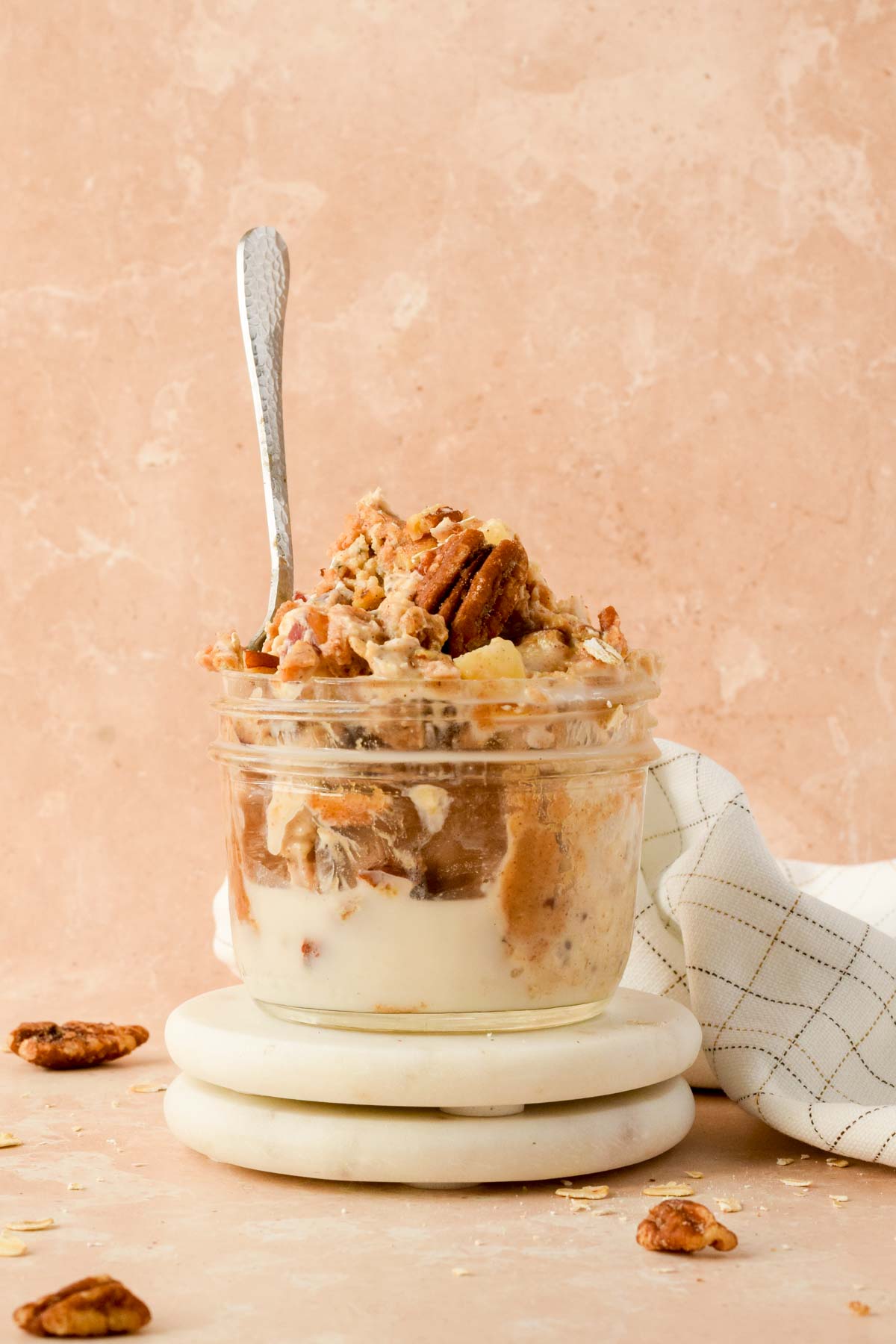 pecan pie overnight oats in a small glass jar with silver spoon.