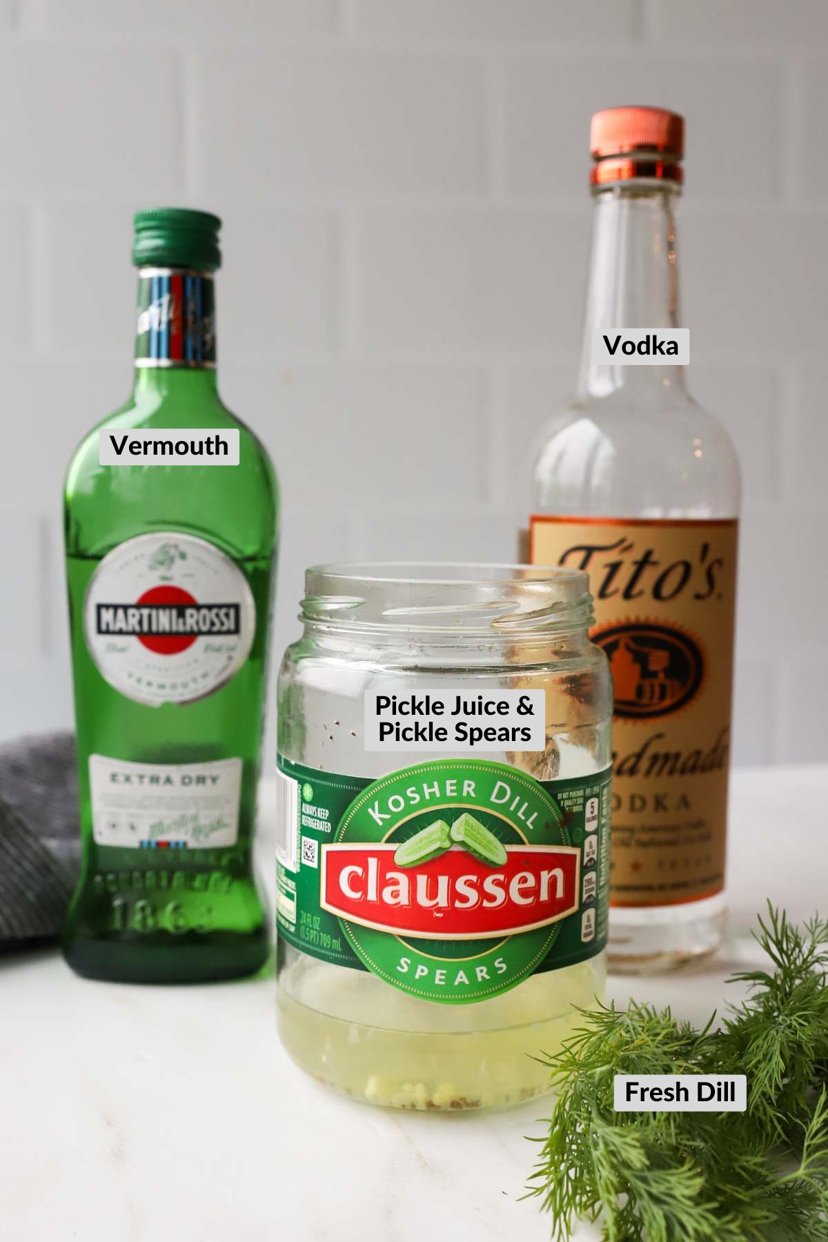 ingredients needed for pickle juice martinis on white background with labels.