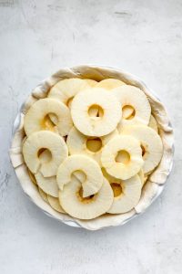 Round apple slices stacked inside store-bought pie crust.