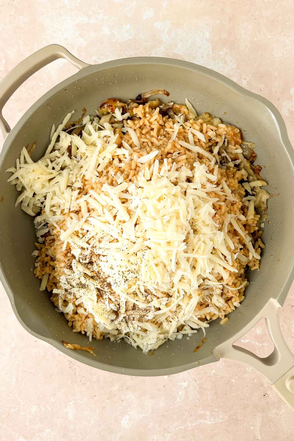 french onion rice in skillet with grated cheese on top.