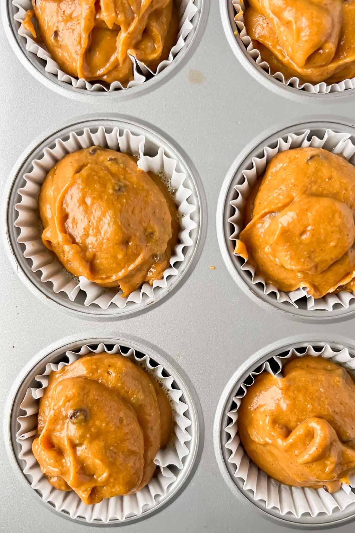 pumpkin protein muffin batter in muffin tin.