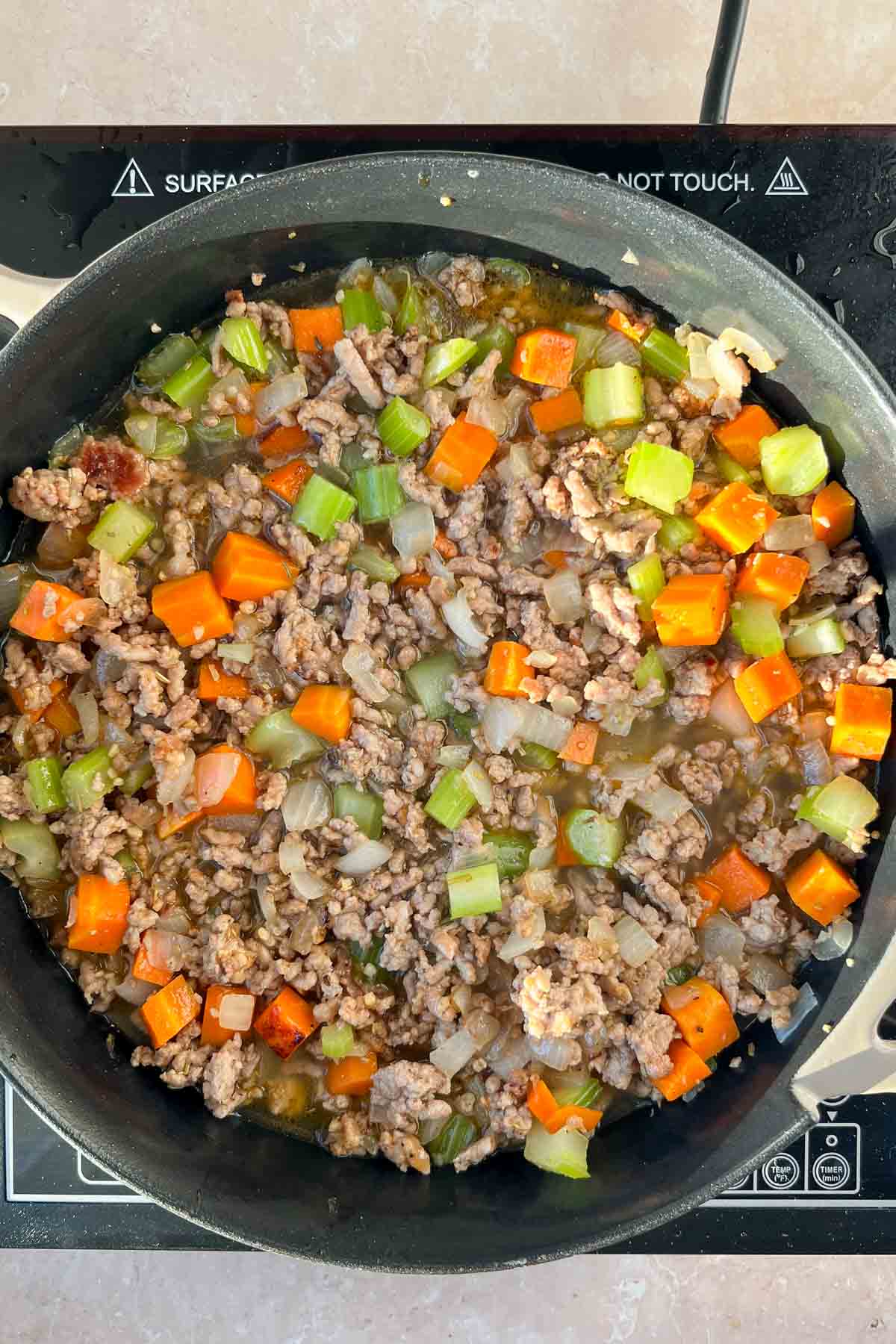 ground sausage and chopped celery, onions, and carrots in skillet with proth.