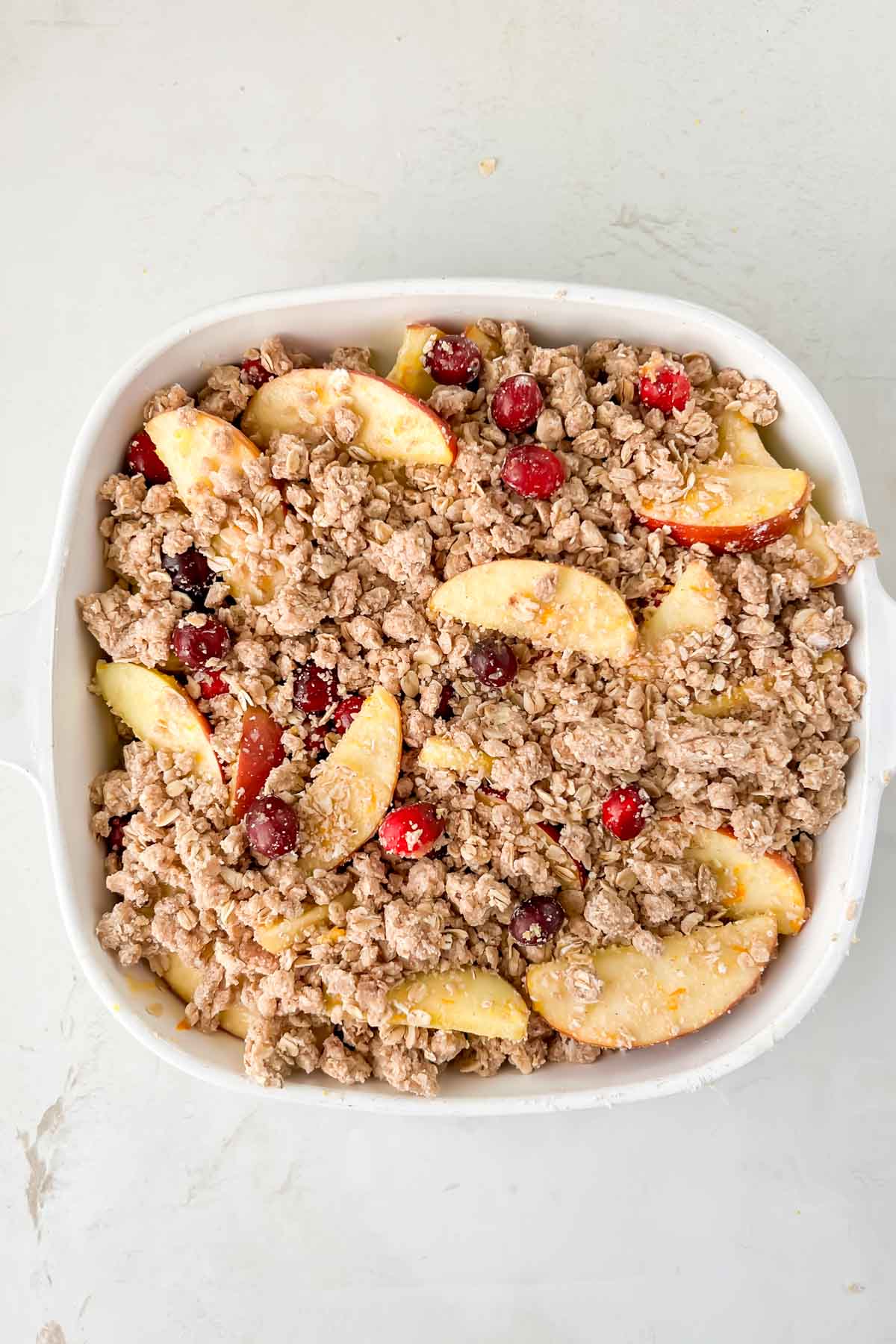 oatmeal streusel topping spread over cranberry and apple mixture before baking. 