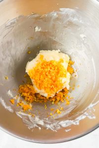 butter with zested orange in silver mixing bowl.