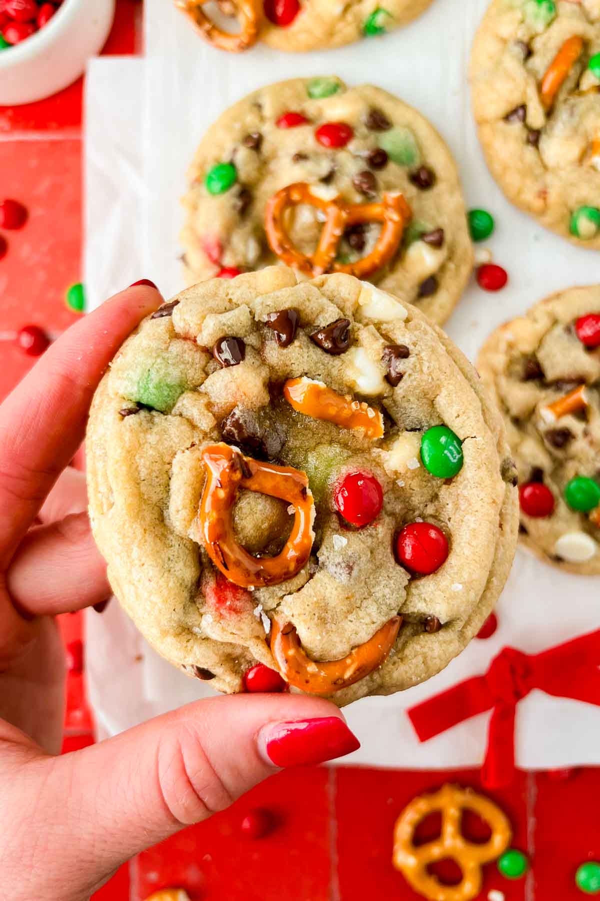 hand holding kitchen sink christmas cookie with additional cookies in background.