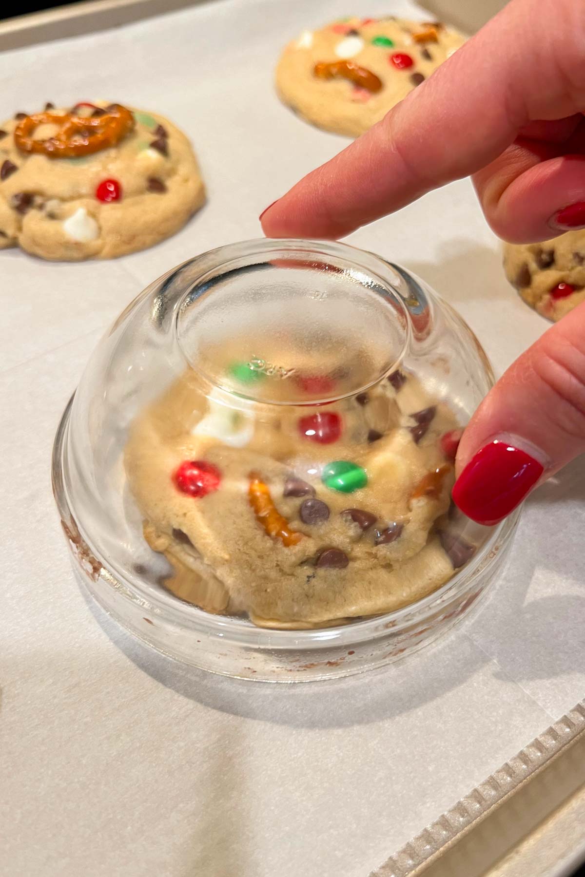 kitchen sink christmas cookie dough on parchment with glass bowl over top to shape.