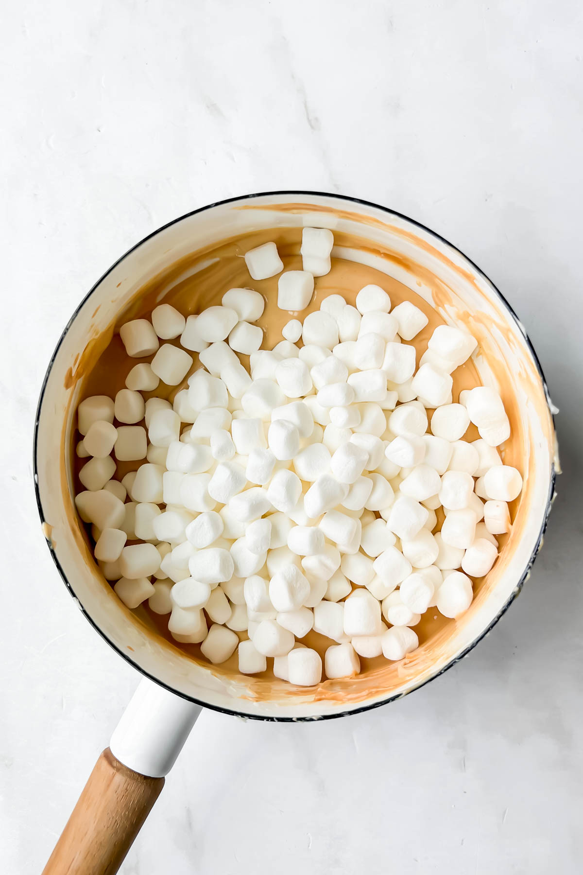 mini marshmallows poured in on top of melted peanut butter and white chocolate. 