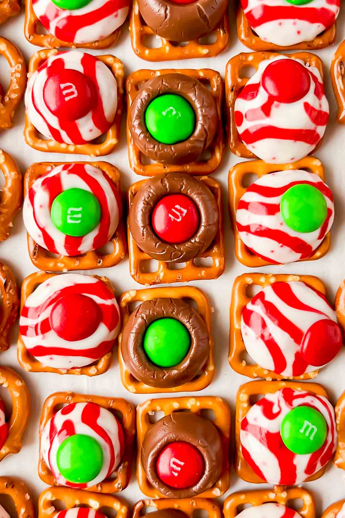 square pretzels topped with melted hershey kisses and m&ms on top.