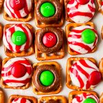 square pretzels topped with melted hershey kisses and m&ms on top.