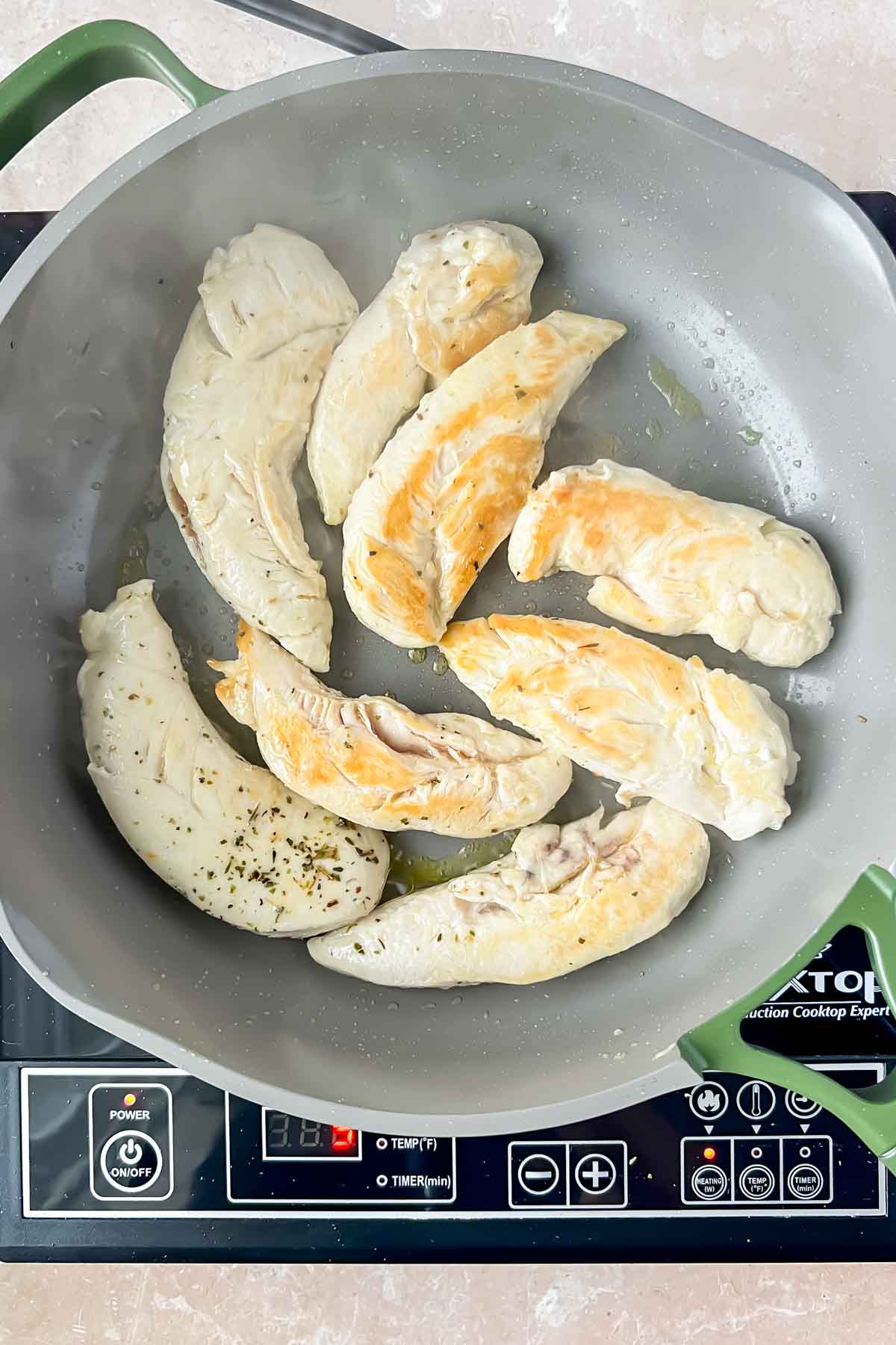 cooked chicken tenderloins in gray skillet.