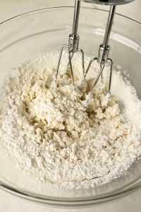 whipped cottage cheese and cake mix being beat together with a hand mixer.