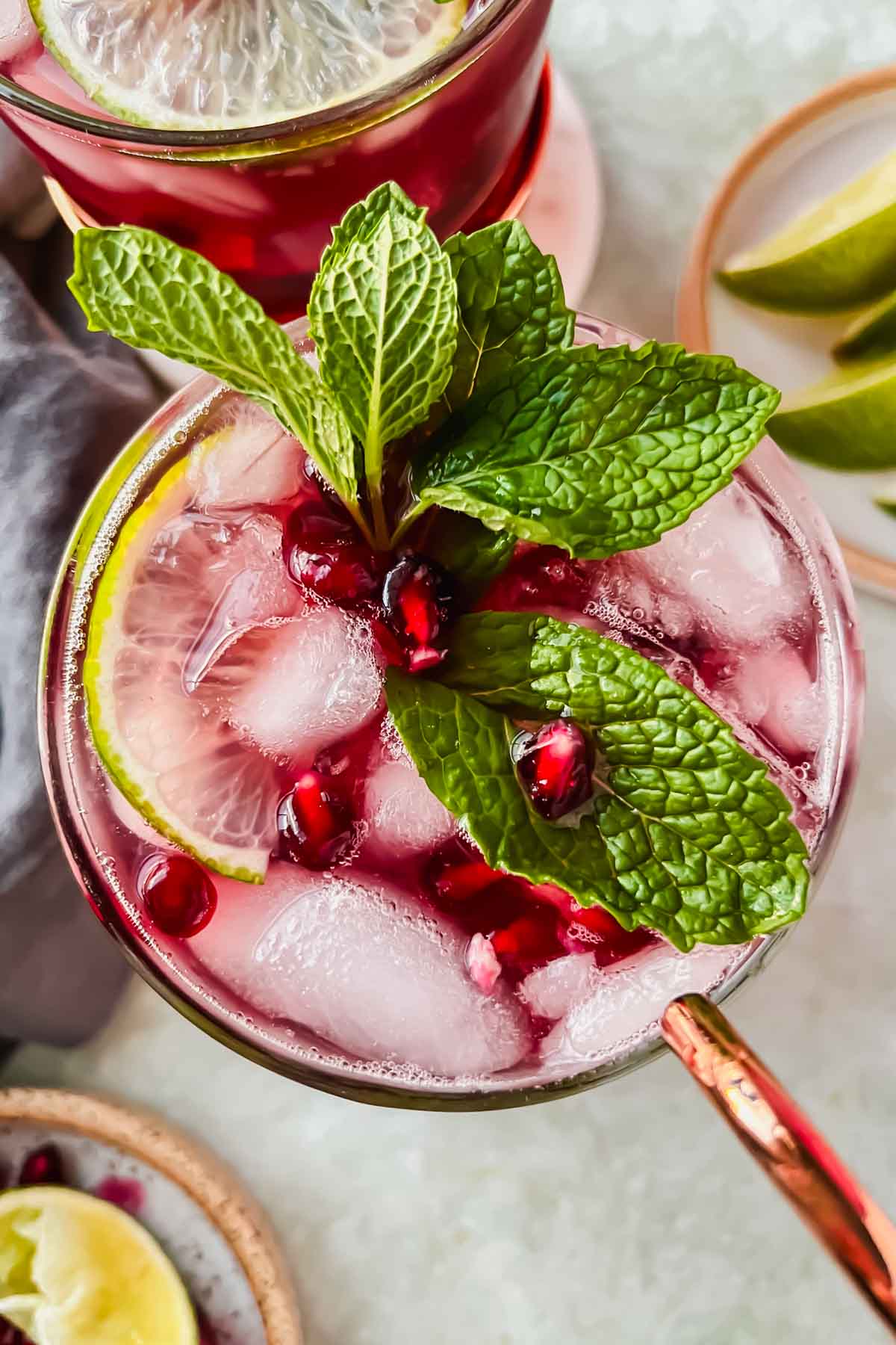 pomegranate moscow mule in copper mug garnished with fresh mint and pomegranate seeds.