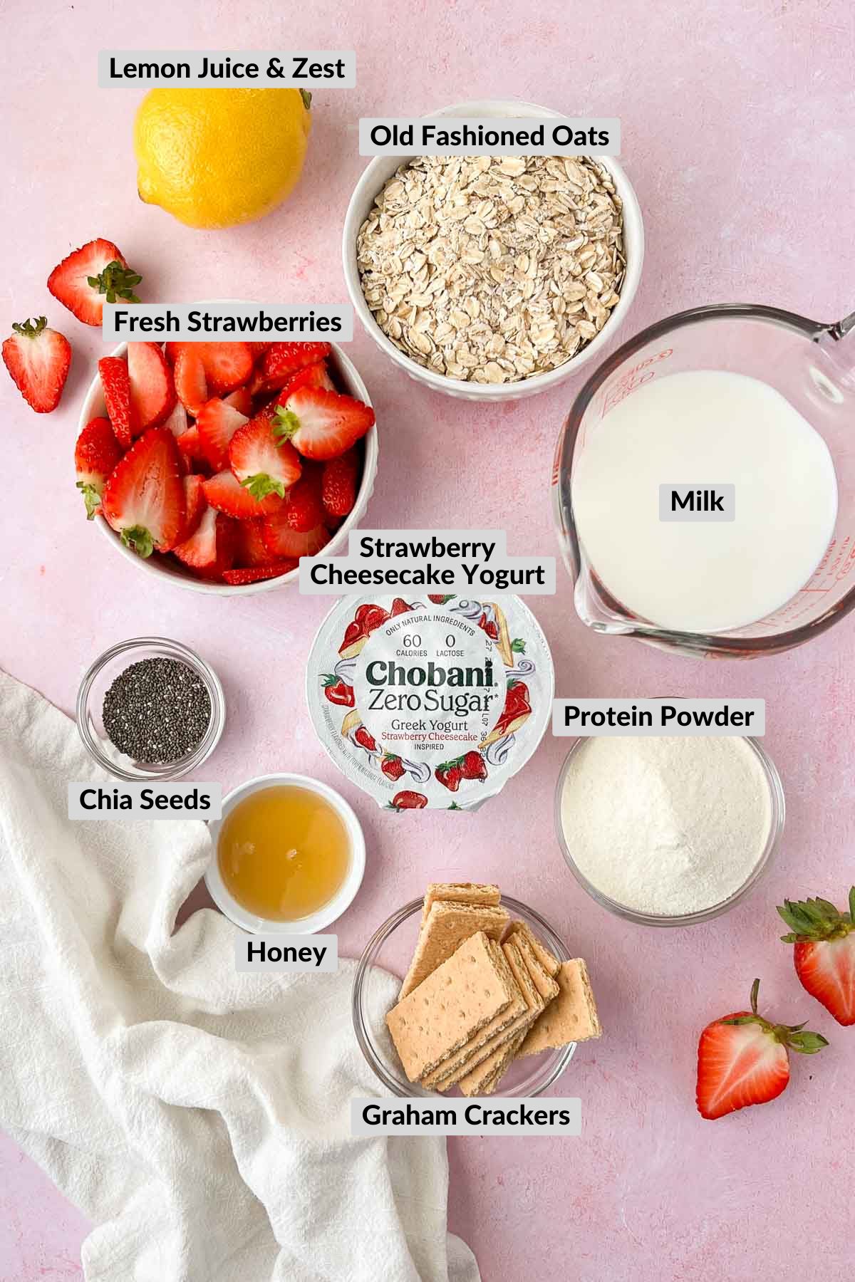 labeled strawberry cheesecake overnight oats ingredients in individual bowls.