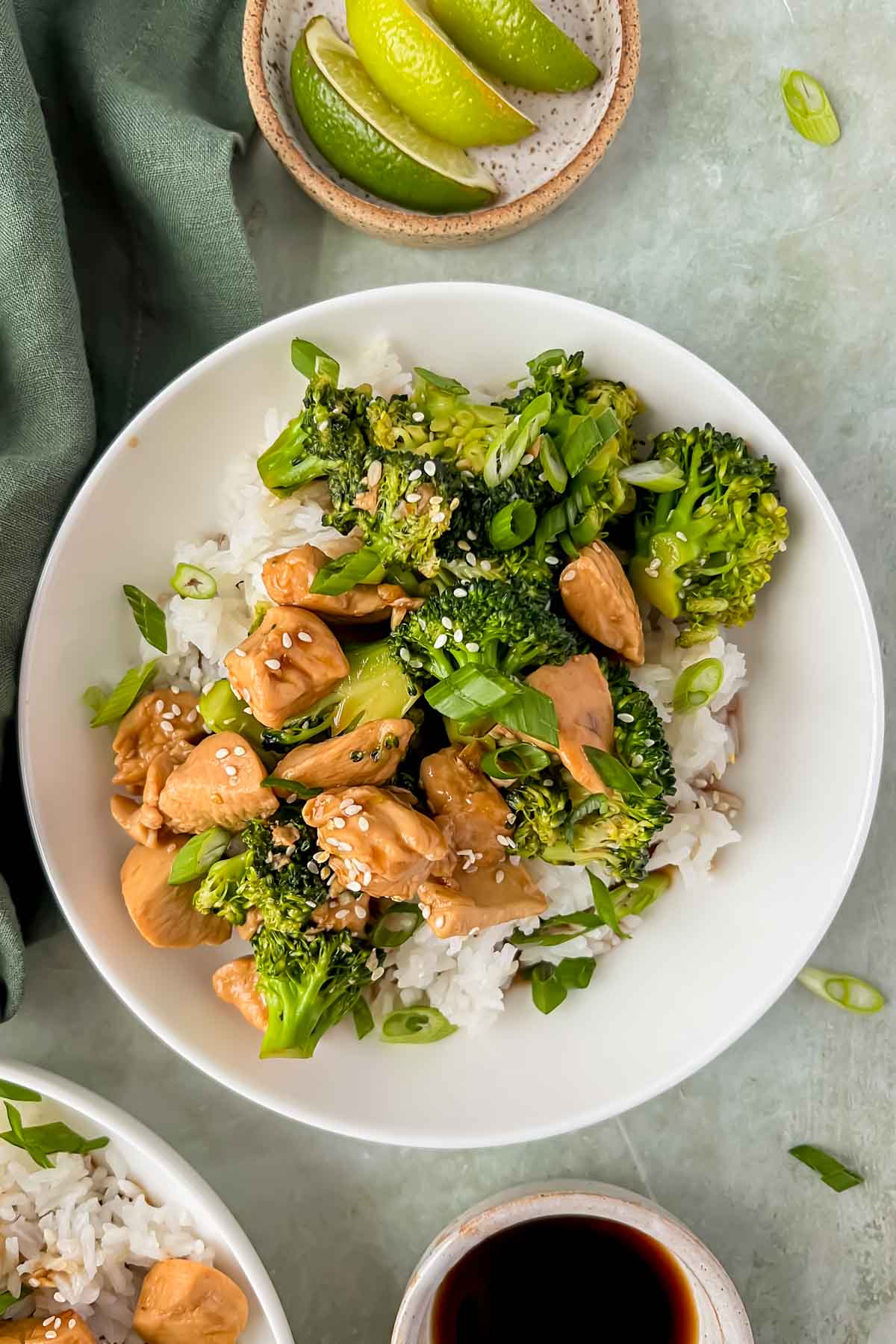 teriyaki chicken and broccoli served over white rice in white bowl.