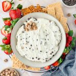 cottage cheese cookie dough dip in gray serving bowl surrounded by pretzels, graham crackers, and strawberries.