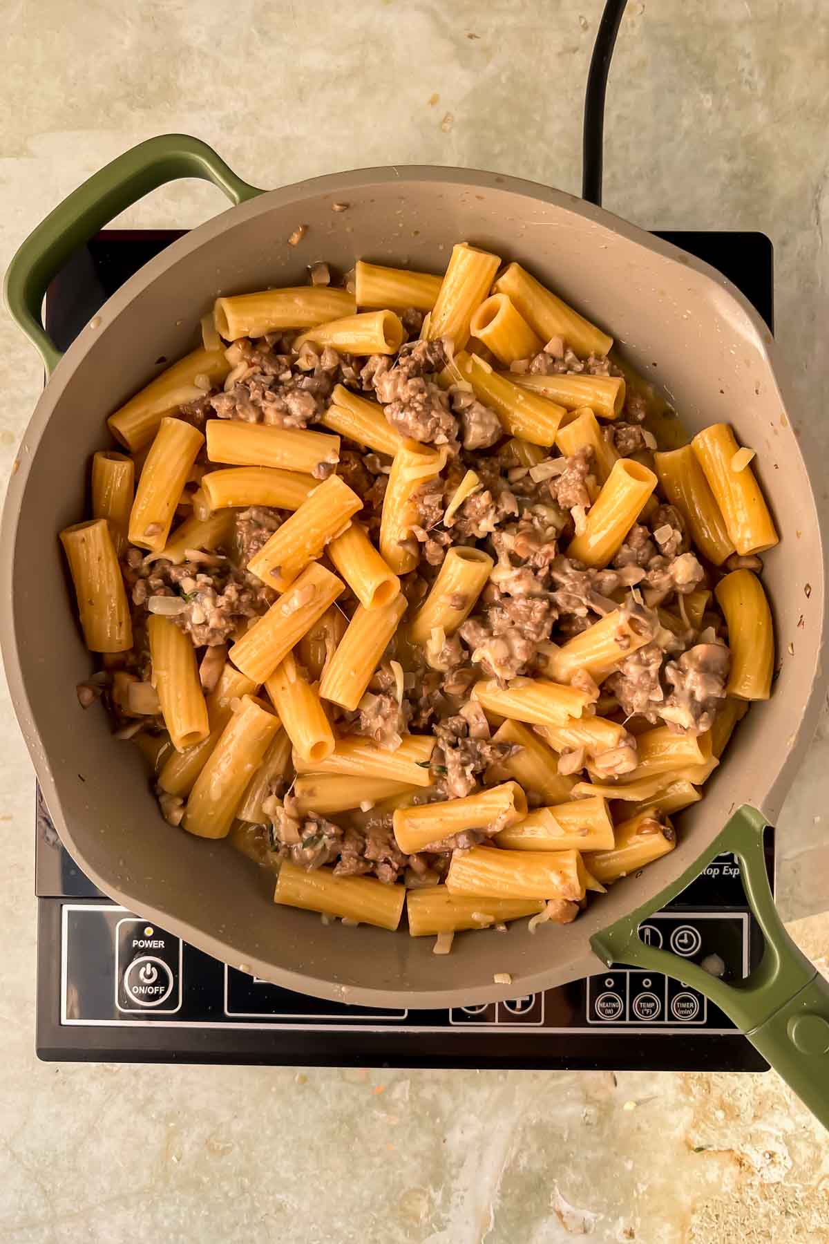 pasta and ground meat mixture in gray skillet.