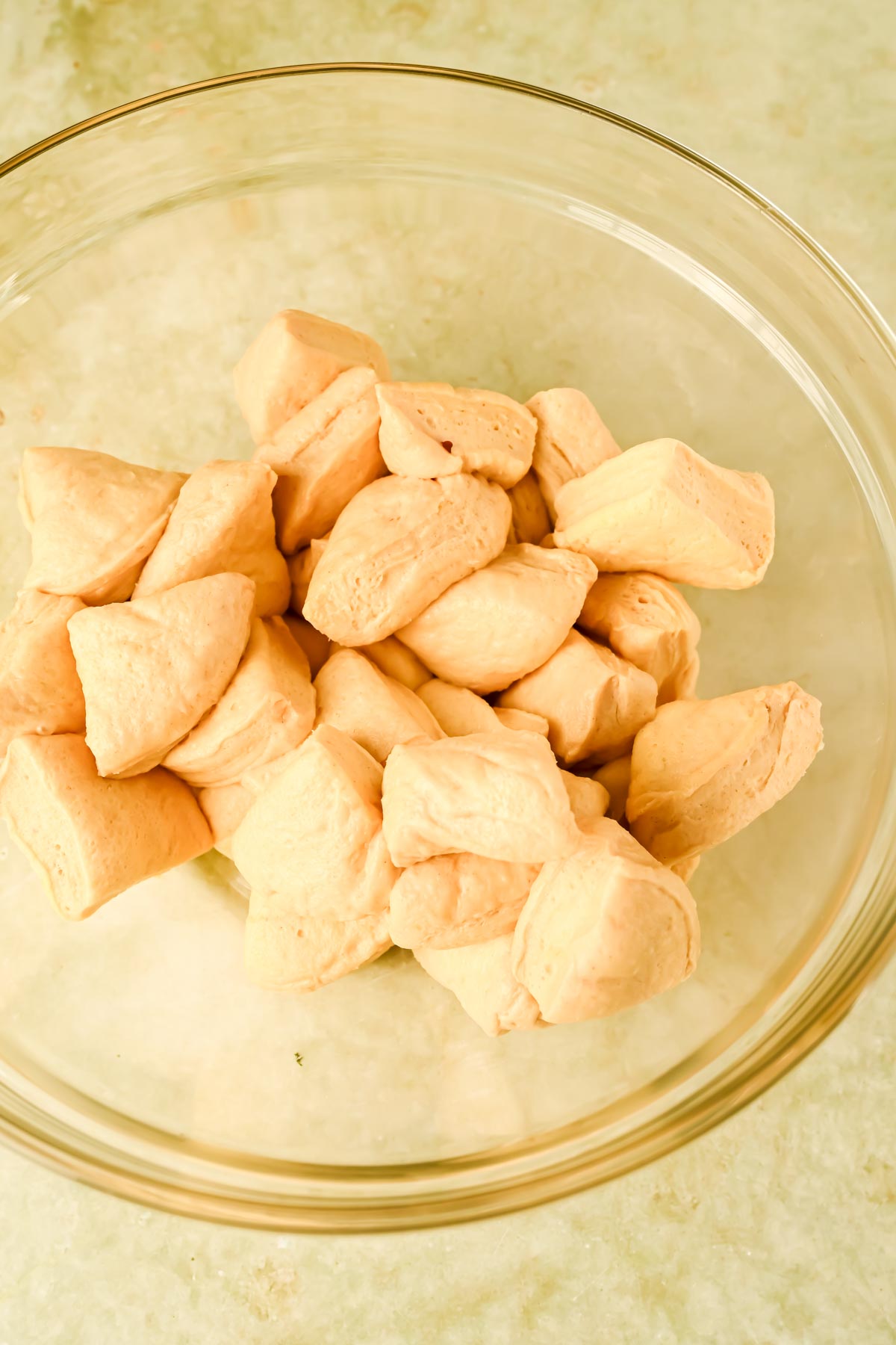 raw biscuit pieces in glass mixing bowl.