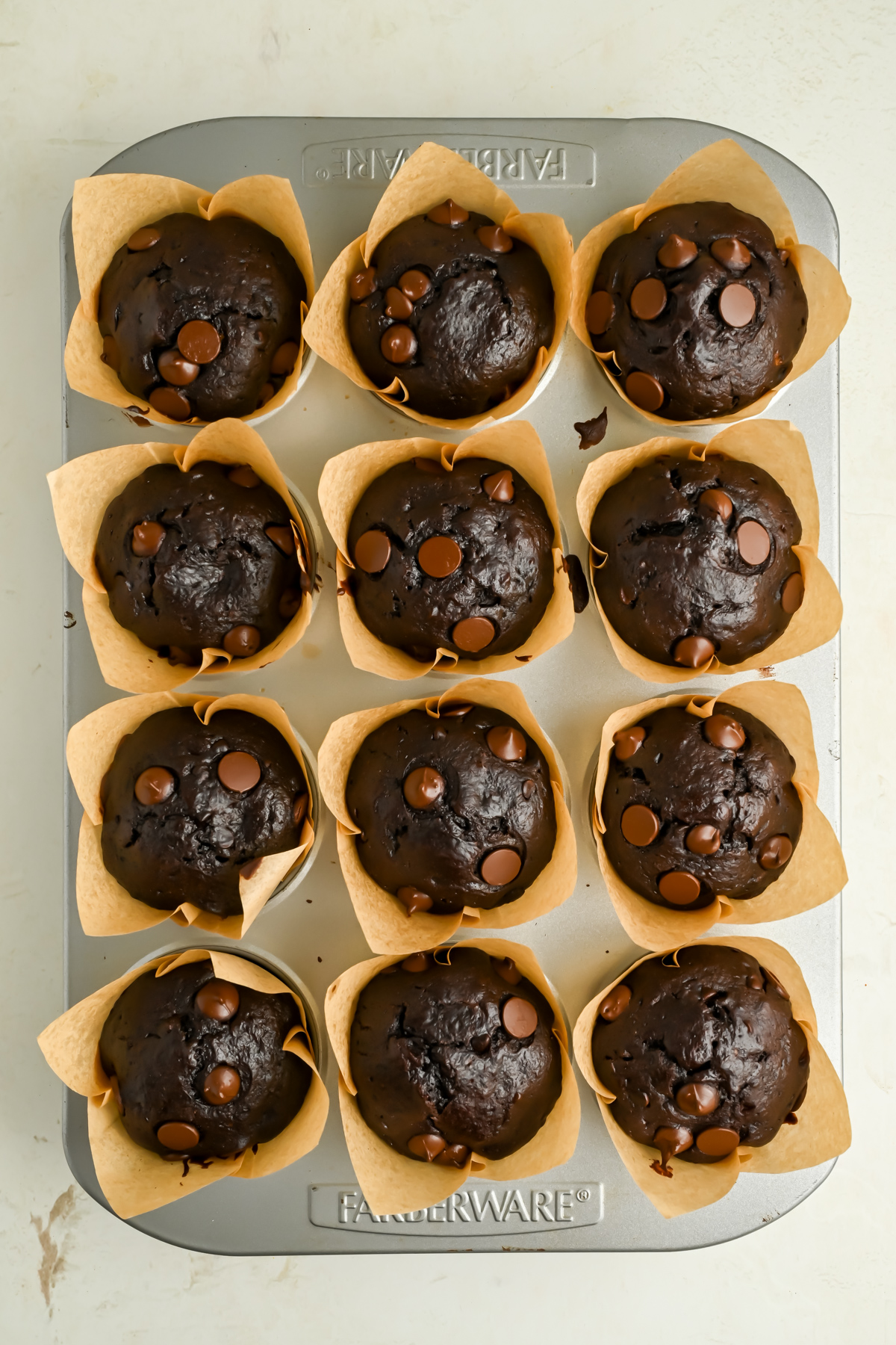12 freshly baked One Bowl Double Chocolate Banana Muffins in a muffin tin.