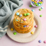 easter M&M cookies stacked in a tower on white plate.