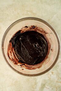 brownie batter mixed together in glass mixing bowl.