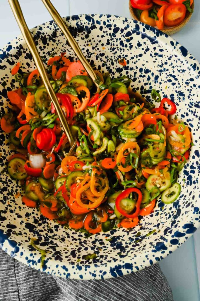 herbs, cucumber, carrots, onion and peppers thinly sliced and tossed in large mixing bowl.