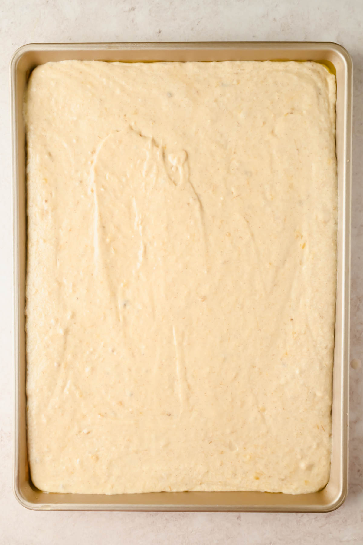banana sheet cake batter spread into large sheet pan.