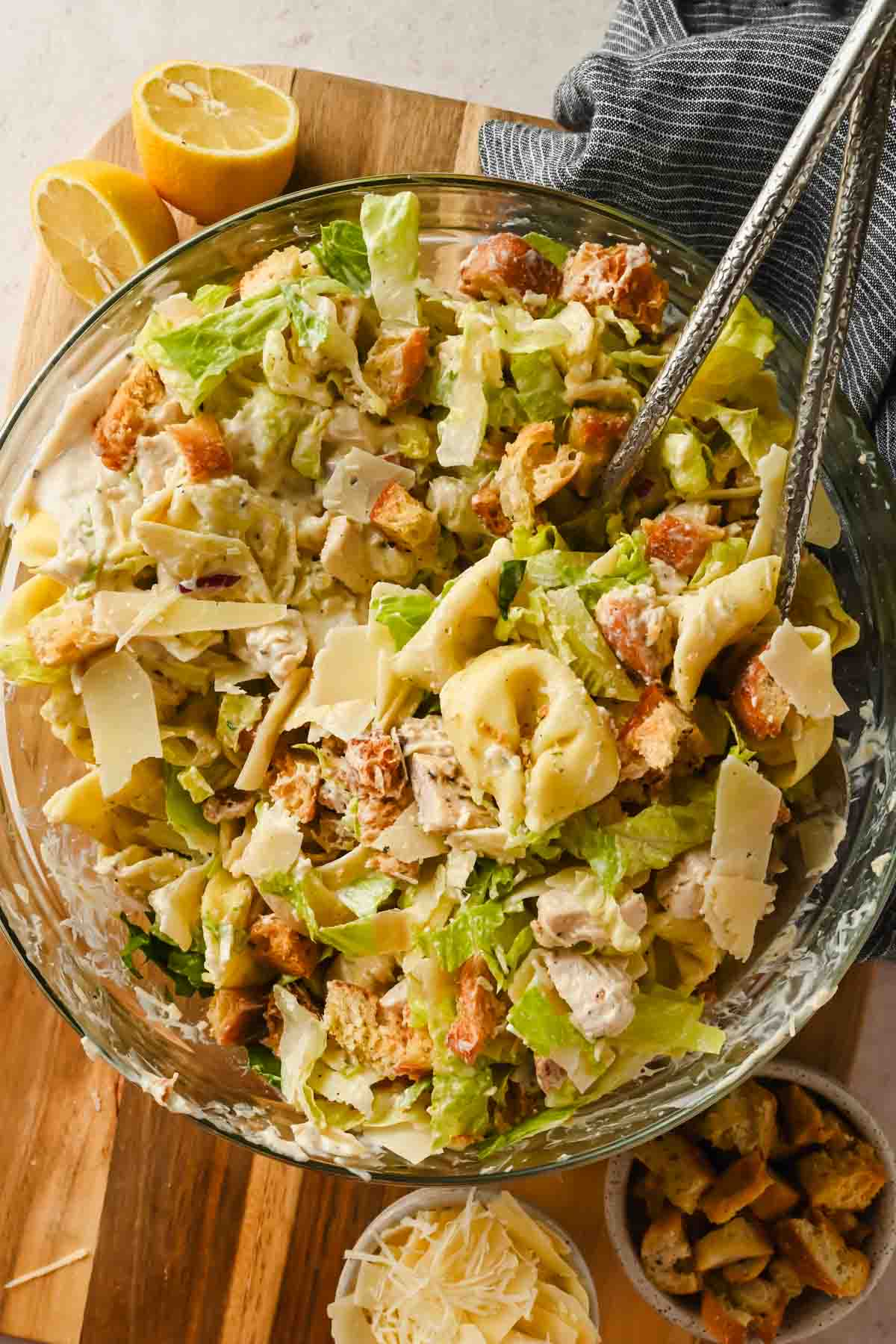 tortellini pasta salad with caesar dressing tossed in glass bowl.
