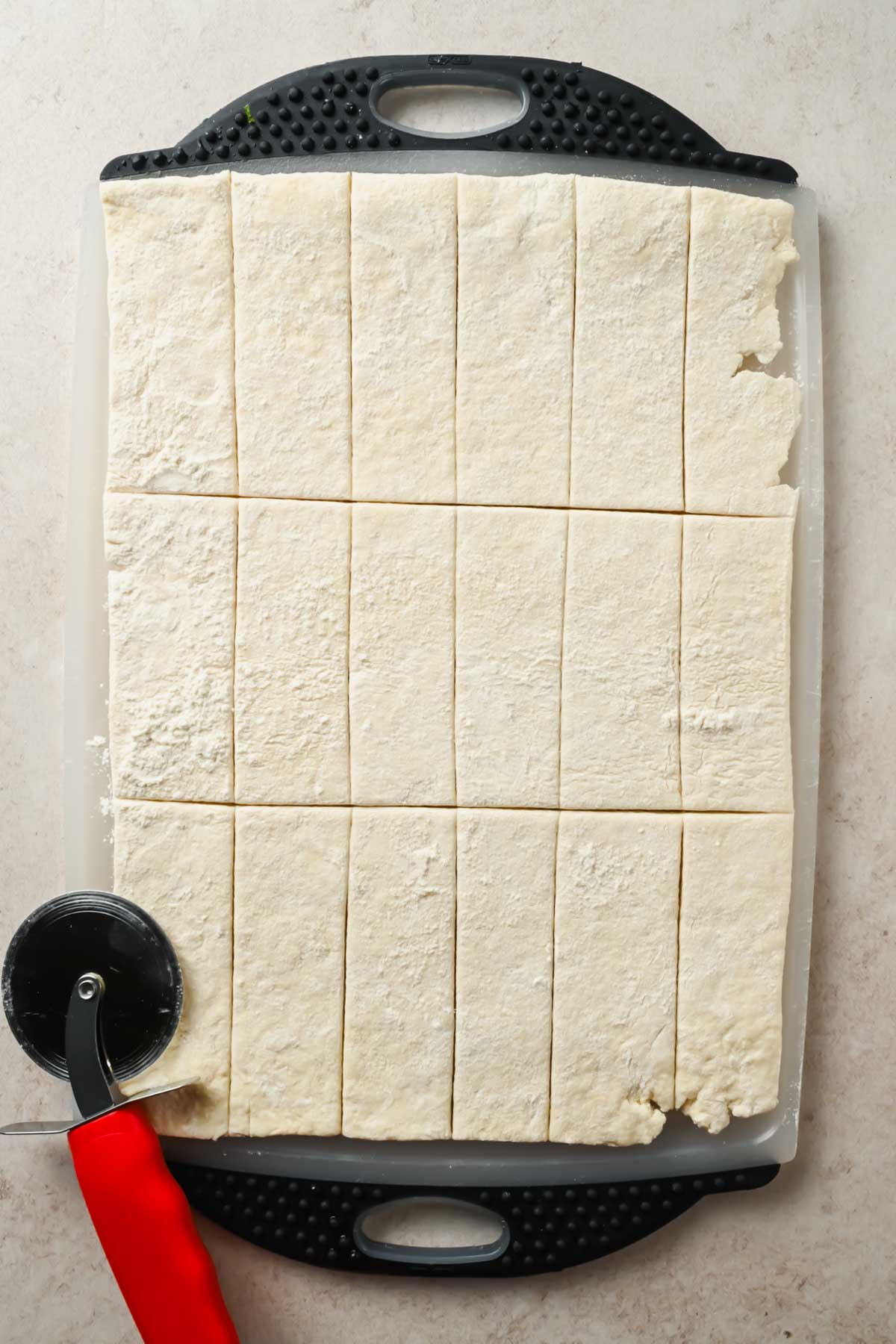 dough spread on cutting board sliced into thin strips.