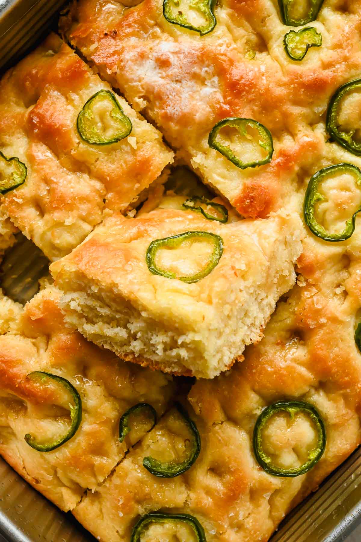 honey jalapeno cornbread cut into squares in large backing tray.