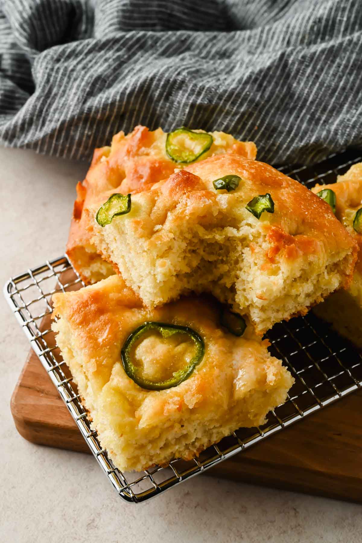 slices of honey jalapeno cornbread stacked on top of each other on wire cooling rack.
