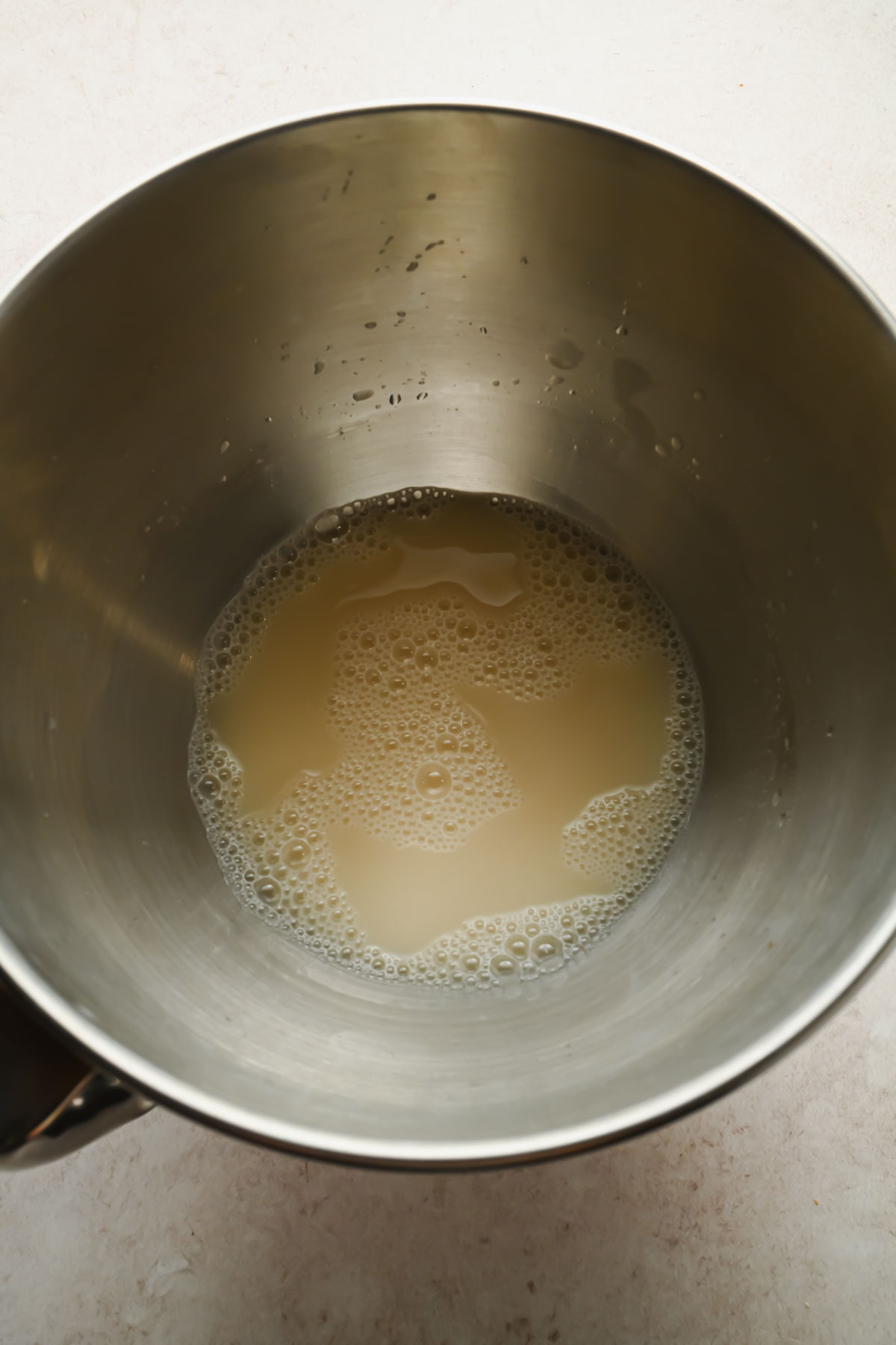 water and yeast mixed in bowl of a stand mixer.