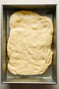 raw focaccia cornbread dough prior to it rising in baking dish before baking.