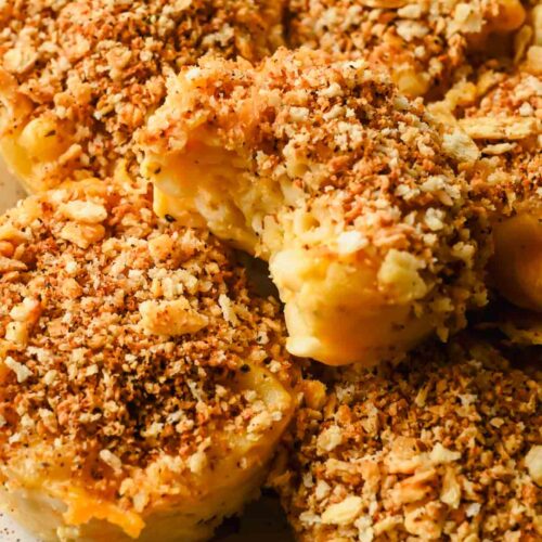 mac and cheese muffins topped with breadcrumbs on speckled plate.