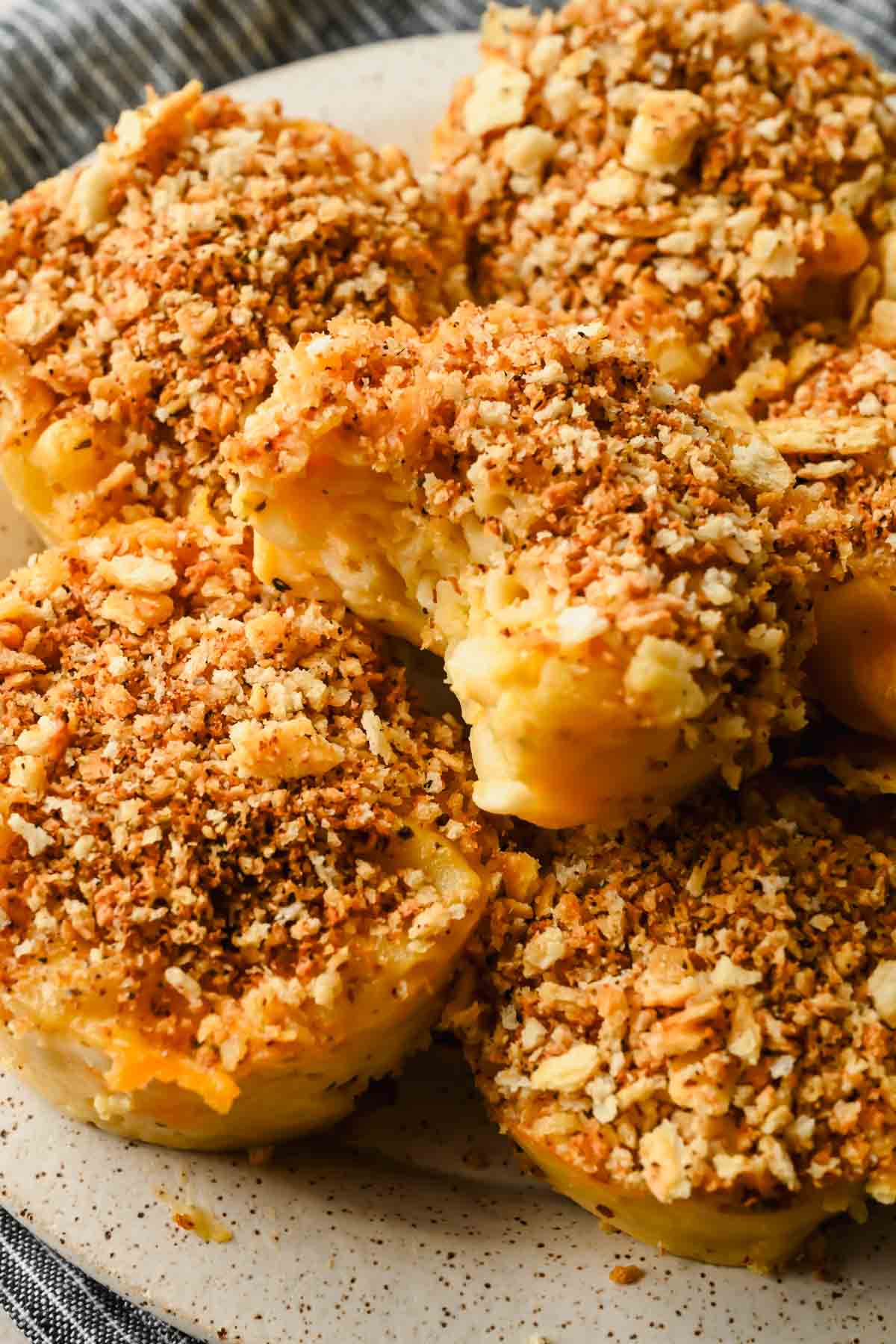mac and cheese muffins topped with breadcrumbs on speckled plate.