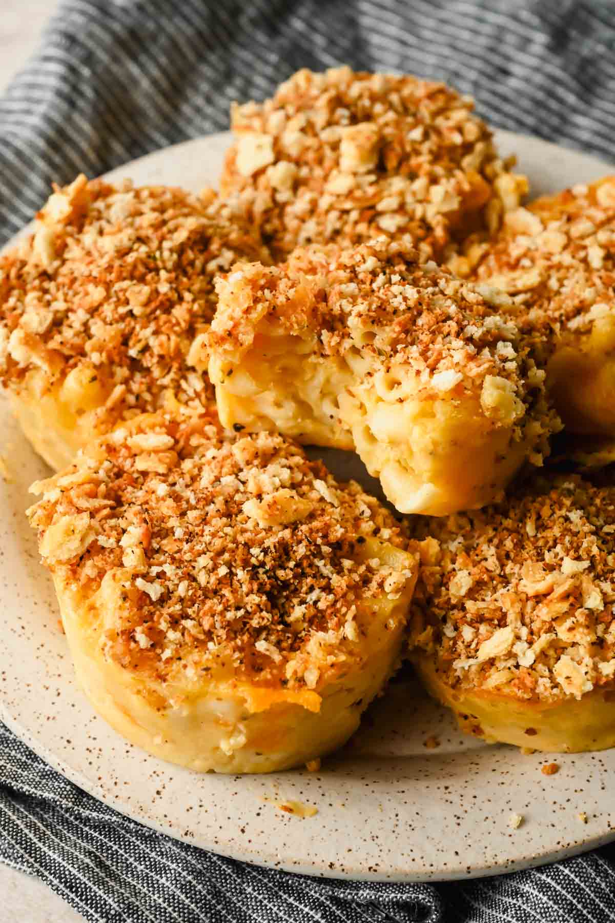 mac and cheese muffins topped with breadcrumbs on speckled plate.
