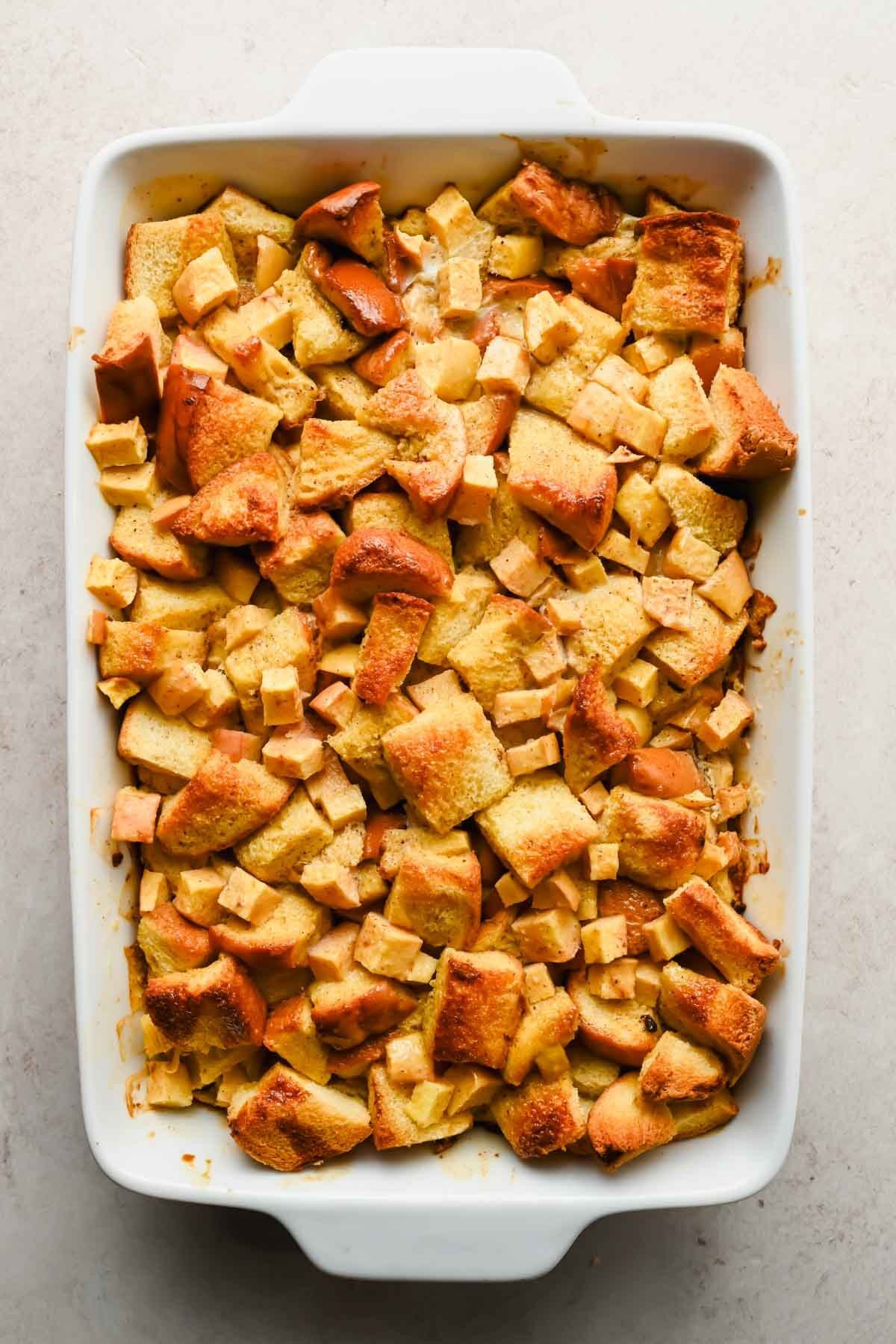 baked overnight eggnog french toast casserole in white baking dish.