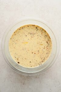 wet mixture for eggnog french toast in glass mixing bowl.