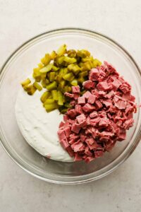 cottage cheese mixture, pickles and chopped pieces of corned beef in large glass mixing bowl.