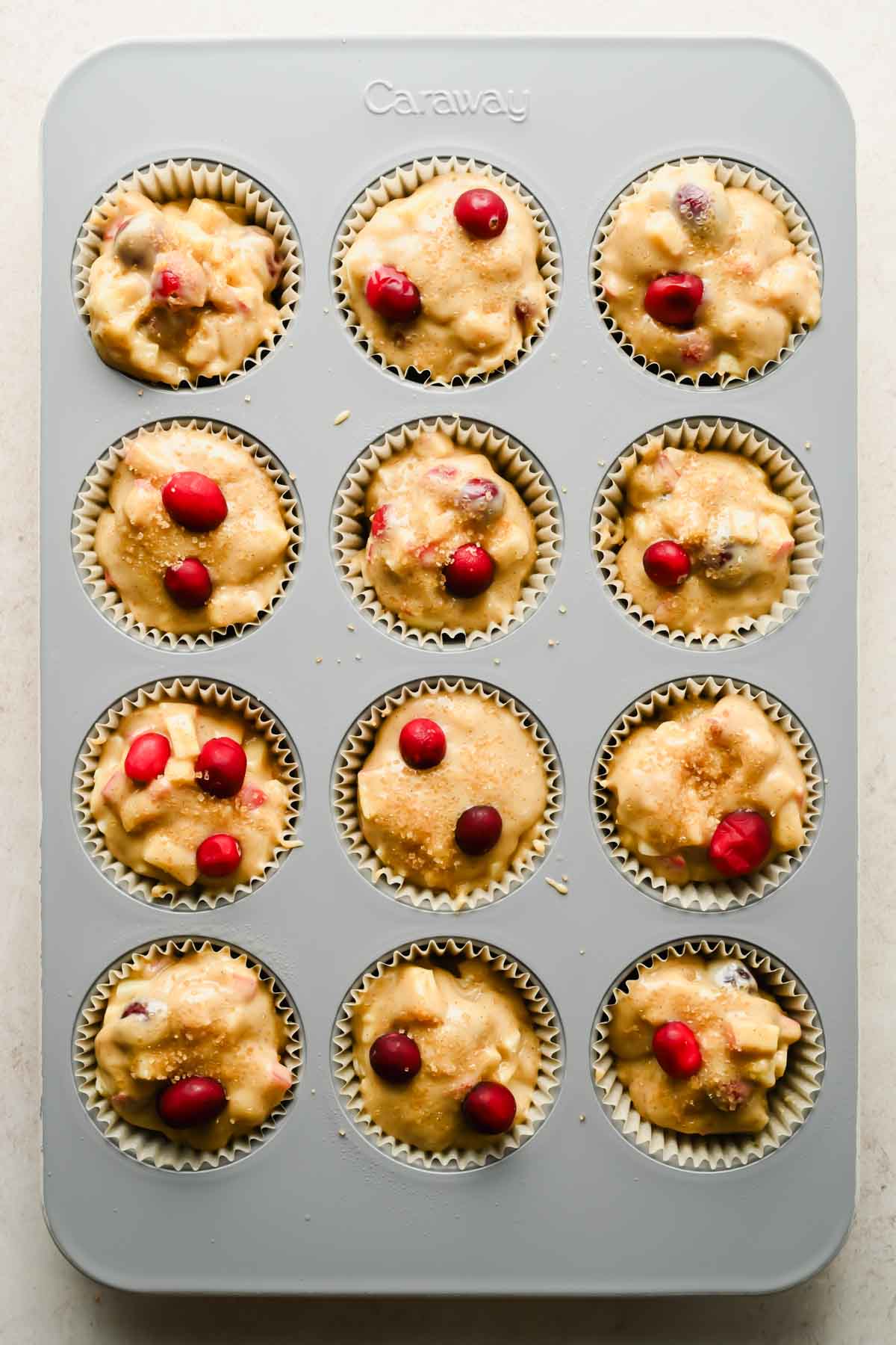 cranberry apple muffin batter in muffin tin.