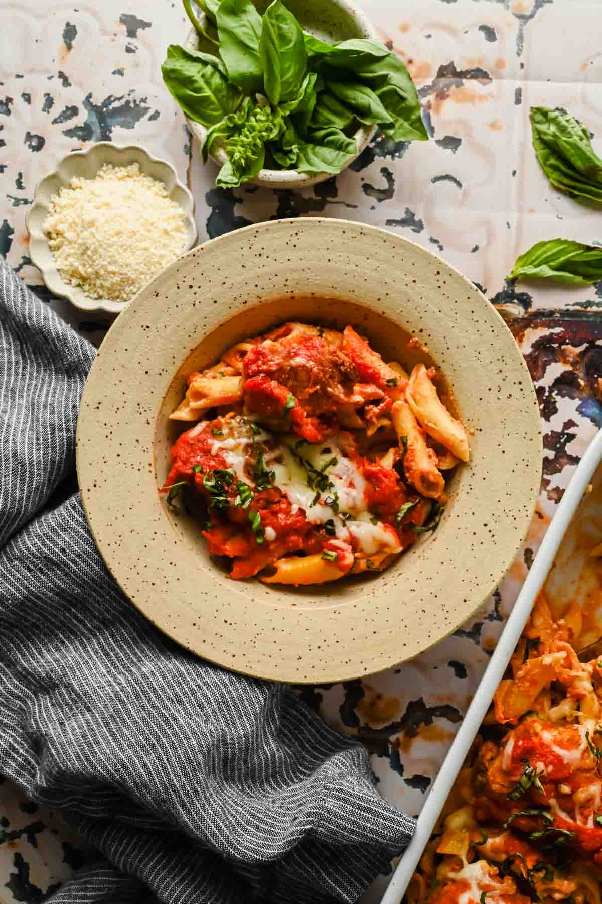 serving of healthier chicken parm in speckled bowl.