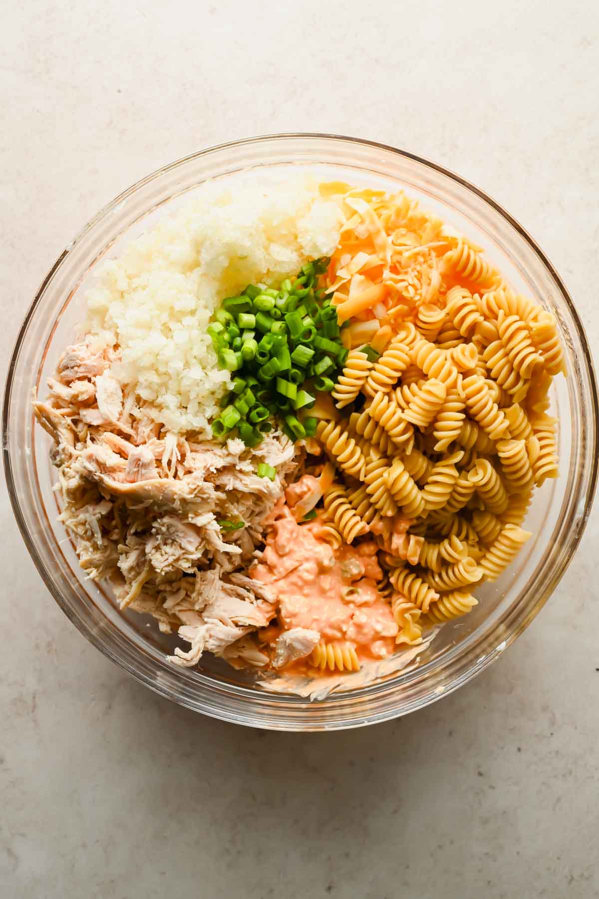 ingredients for buffalo chicken casserole in large glass mixing bowl.