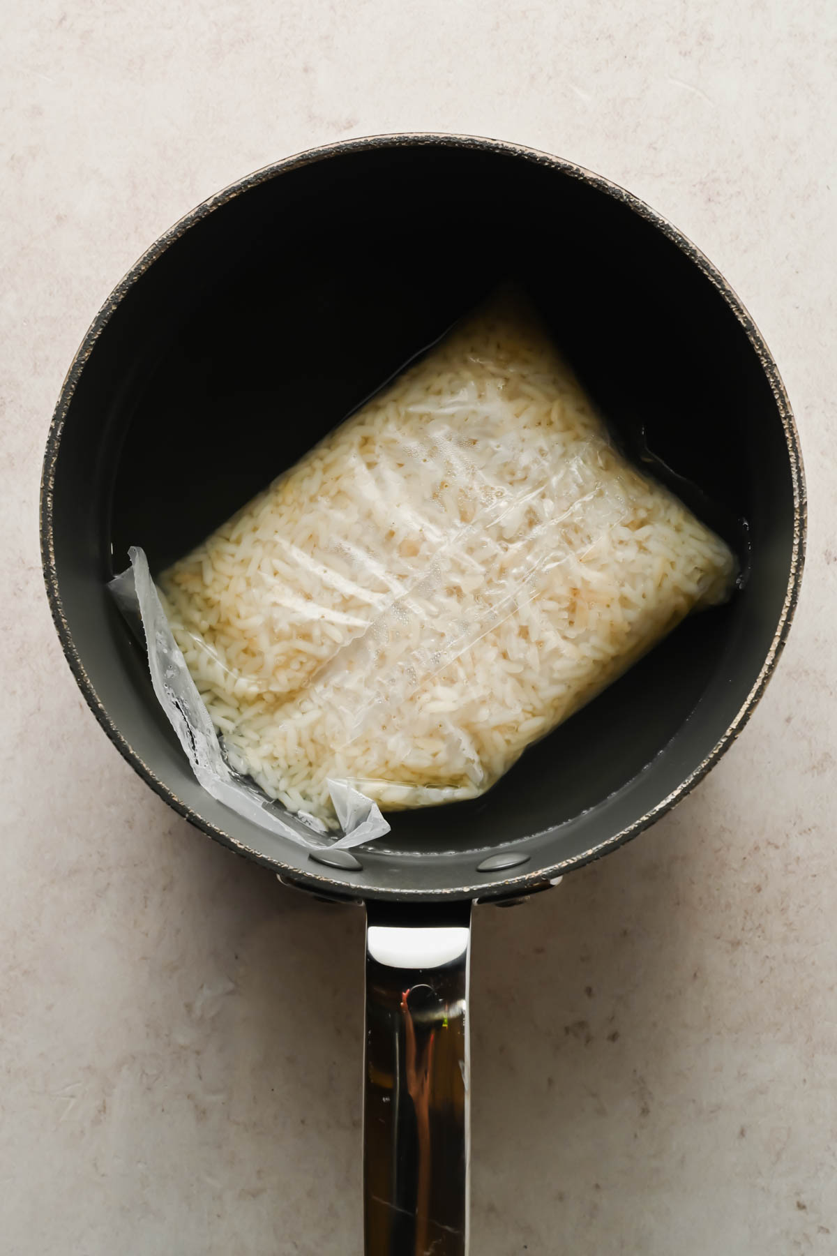bagged white rice in pot of boiling water.