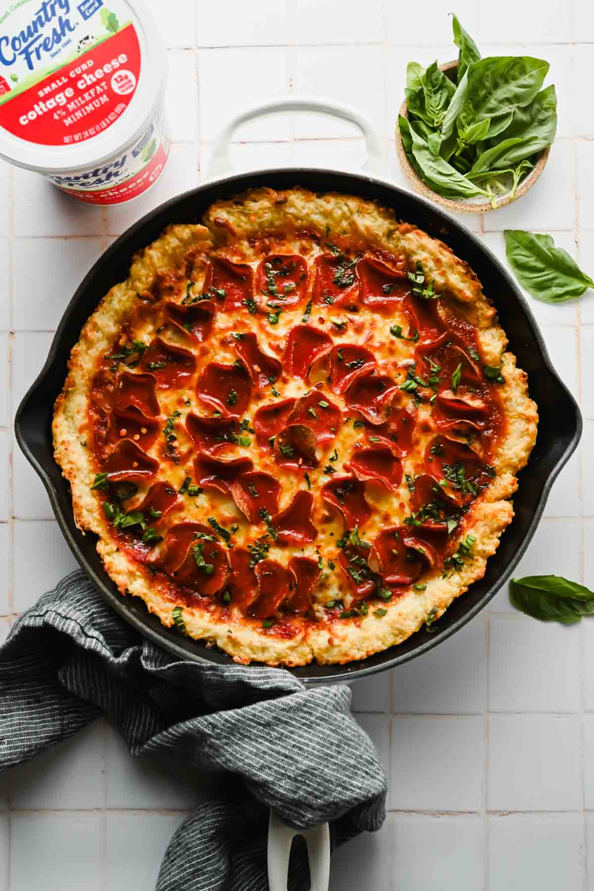 skillet pizza topped with melty cheese, pepperonis and fresh chopped herbs.