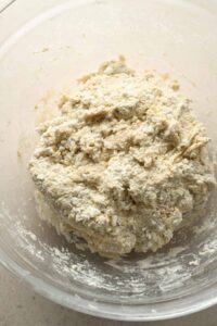 pizza crust ingredients mixed in glass mixing bowl.