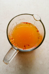 Nuoc Cham Chili Garlic Sauce in large glass measuring cup.