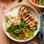 Vietnamese Vermicelli Bowl with lemongrass chicken, fresh veggies and herbs plated with chopsticks.