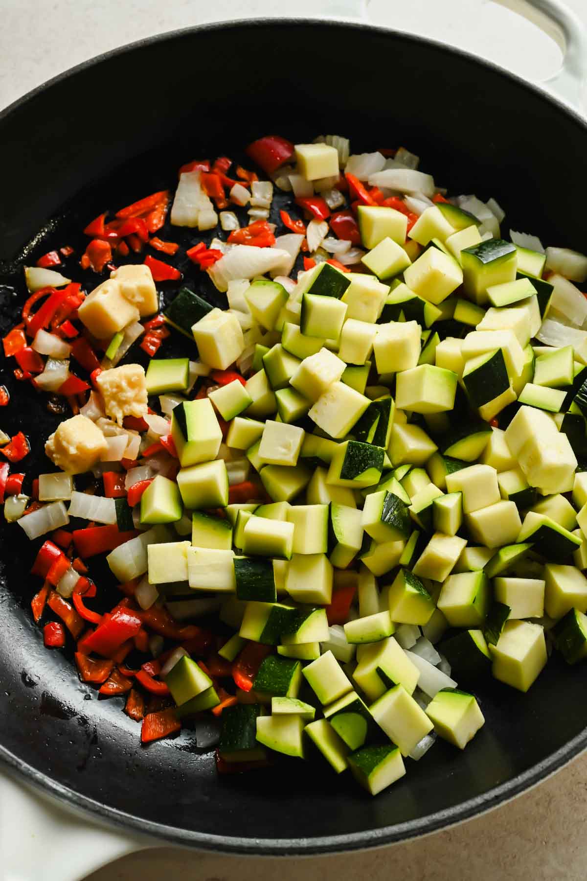 diced onions, zucchini and bell peppers in large cast iron skillet.