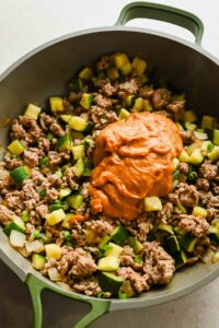lamb stir fry cooked in large skillet topped with a peanut ginger sauce.