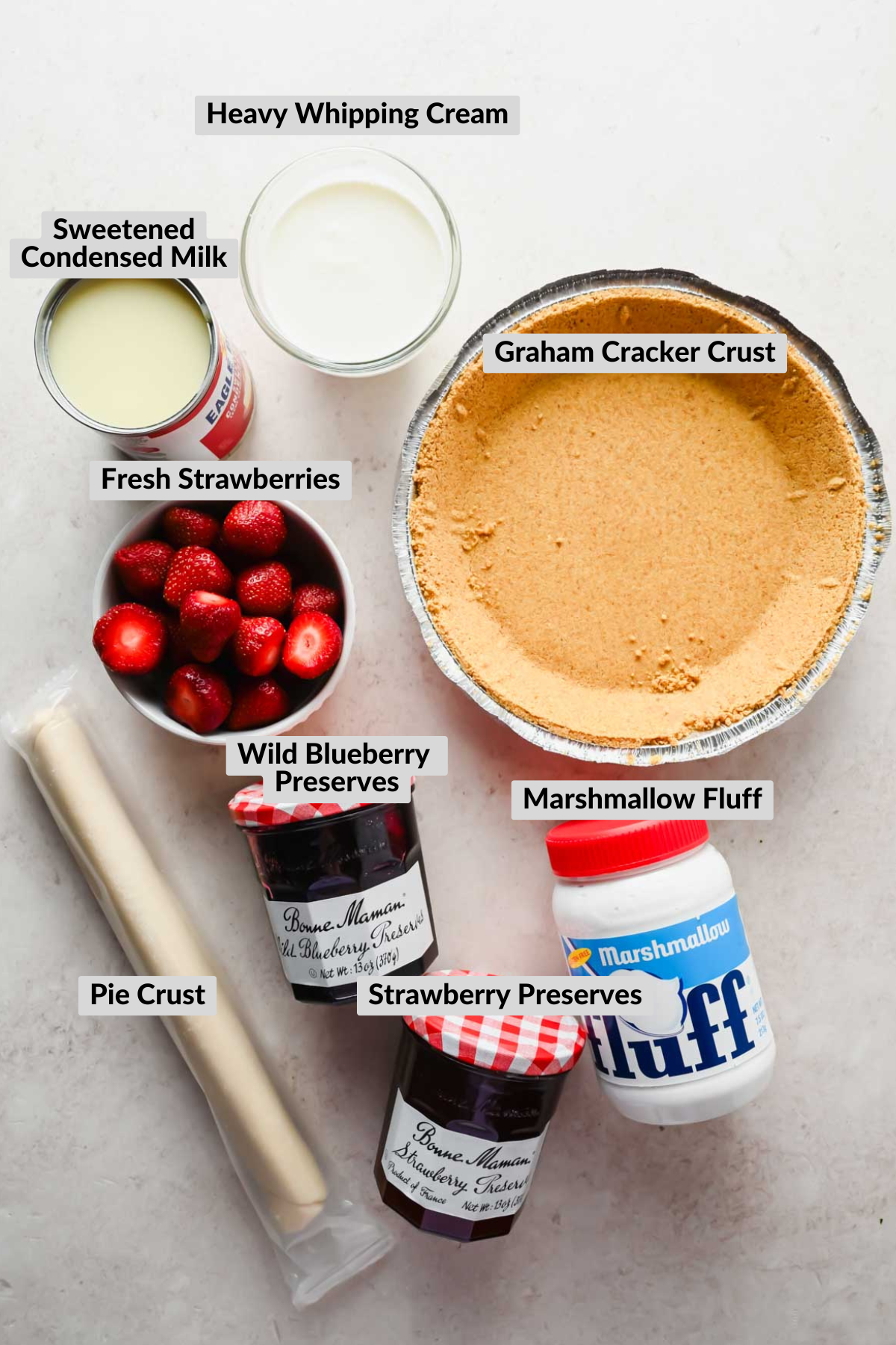 labeled ingredients for strawberry no churn ice cream laid on neutral background.