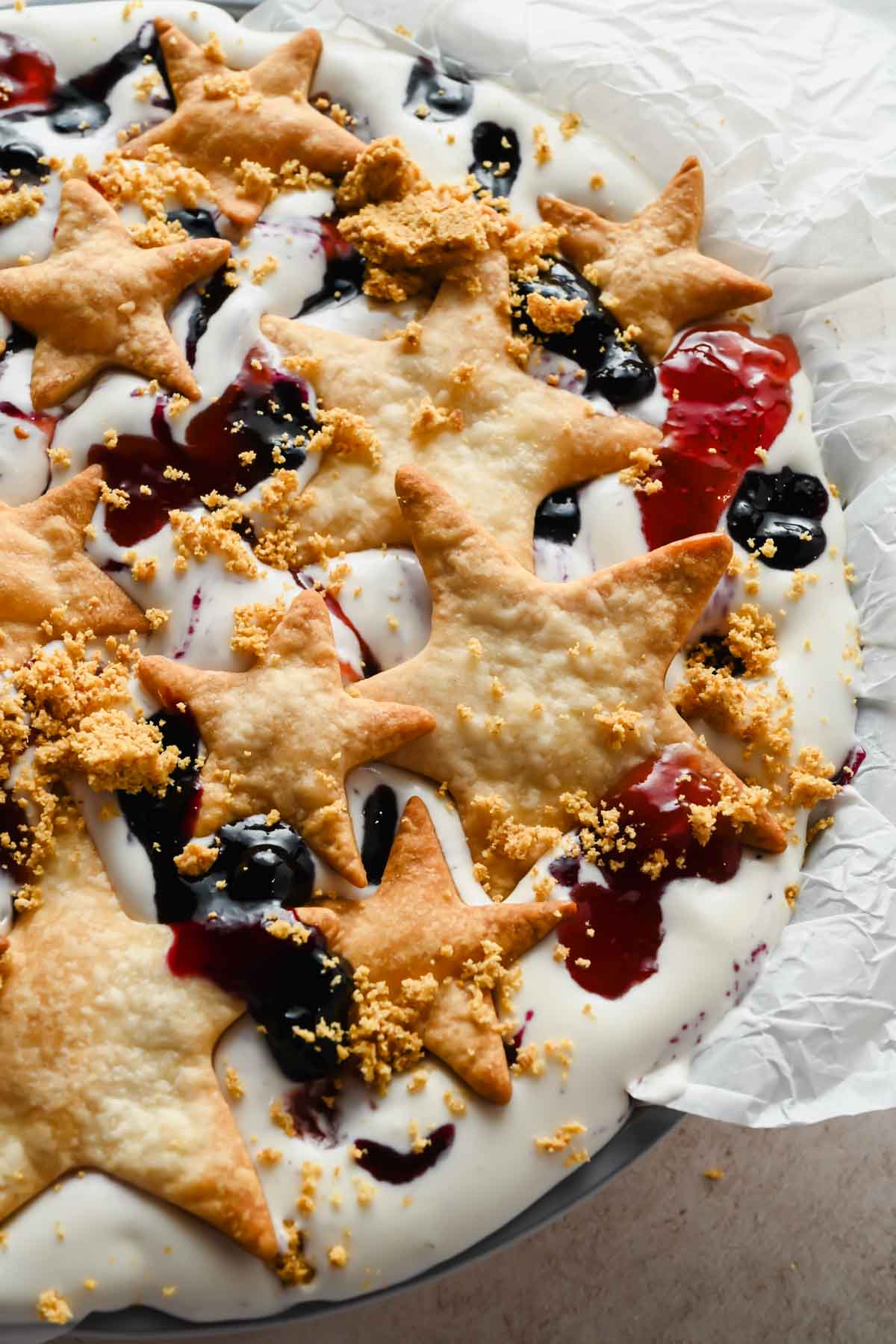 baked pieces of pie crust layered onto berries and cream ice cream.